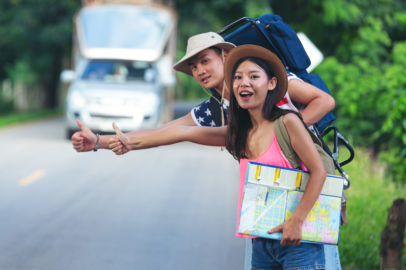 Travelers Hitchhiking on a Scenic Road